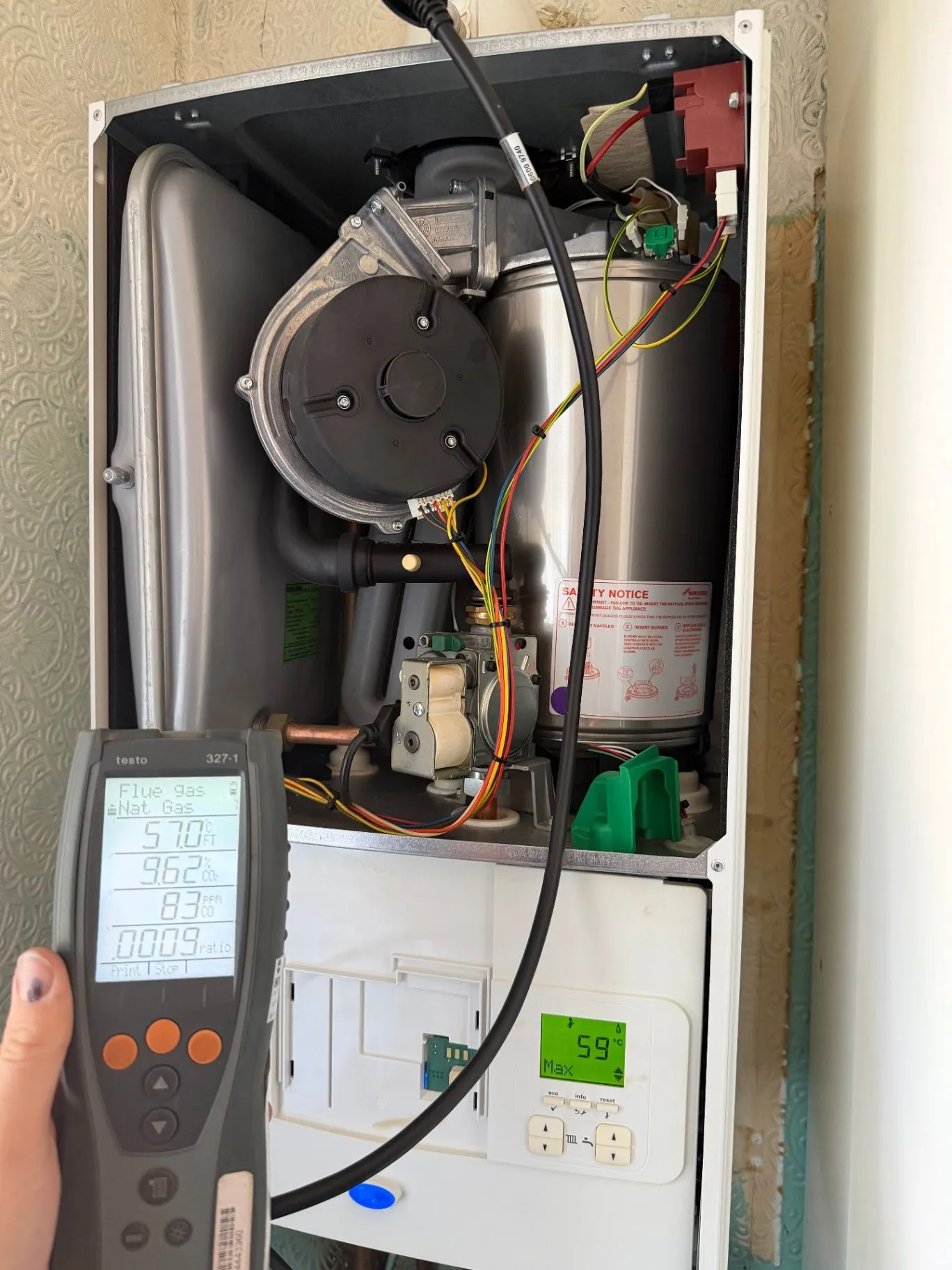 Open boiler casing with a flue gas analyser connected during a service check