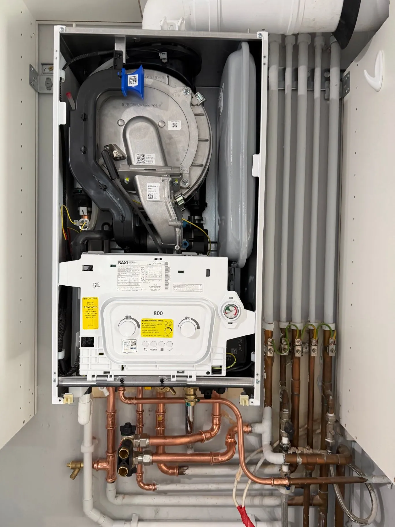 Open boiler casing showing internal components and copper connections